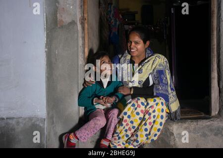 indische ländliche Mutter und Tochter sitzen vor der Tür des Hauses Stockfoto