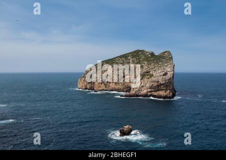 Frühlingstag mit blauem Himmel mit hellweißen Wolken. Blick vom Naturpark Parco Naturale Regionale di Porto Conte auf der Insel Isola Foradada in Mediter Stockfoto