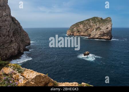 Frühlingstag mit blauem Himmel mit hellweißen Wolken. Blick vom Naturpark Parco Naturale Regionale di Porto Conte auf der Insel Isola Foradada in Mediter Stockfoto