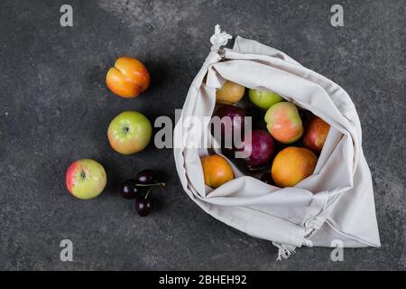 Zero Waste, Kunststoff frei Recycling-Textilwaren Tasche für die Beförderung von Obst (Apfel, Birne, Pflaume, Kirsche) auf dunklem Schiefertafel Hintergrund Stockfoto