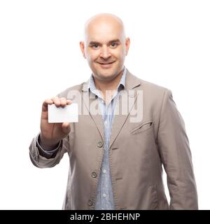 Ein Glatzkopf in beigem Anzug zeigt eine Visitenkarte auf Weiß isoliert. Stockfoto