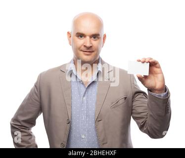 Ein Glatzkopf in beigem Anzug zeigt eine Visitenkarte auf Weiß isoliert. Stockfoto