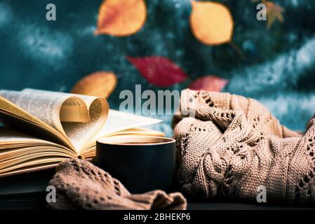 Tasse Kaffee und verfallene Herbstblätter am Fenster, gemütliches Zuhause in der Atmosphäre Stockfoto