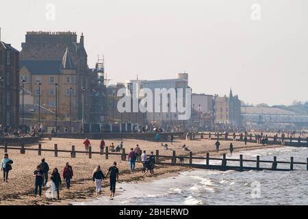 Portobello, Schottland, Großbritannien. 25. April 2020. Blick auf die Menschen im Freien am Samstagnachmittag am Strand und an der Promenade in Portobello, Edinburgh. Gutes Wetter hat mehr Menschen ins Freie gebracht, die wandern und Radfahren. Der Strand scheint voll mit möglicherweise einem Zusammenbruch der sozialen Distanz, die später am Nachmittag stattfindet. Blick entlang des Strandes mit vielen Gästen. Iain Masterton/Alamy Live News Stockfoto