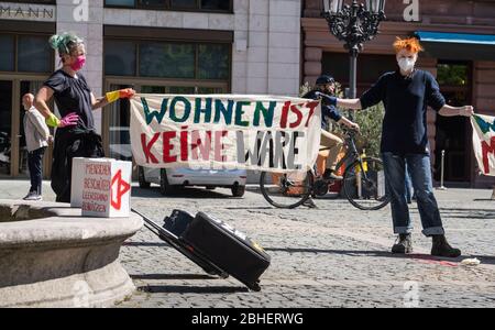 25. April 2020, Hessen, Frankfurt/Main: Demonstranten stehen auf dem Gelände eines Luxushotels in einer Reihe, jeweils zwei Meter voneinander entfernt, mit Koffern und Umzugskartons vor der Alten Oper. Auf einem Banner steht: "Leben ist keine Ware". Zum Thema "Flüchtlinge und Wohnungsmangel in der Corona-Krise" fanden vor zwei Hotels und einer Jugendherberge Aktionen statt. Foto: Frank Rumpenhorst/dpa Stockfoto