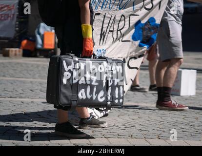 25. April 2020, Hessen, Frankfurt/Main: Demonstranten stehen auf dem Gelände eines Luxushotels in einer Reihe, jeweils zwei Meter voneinander entfernt, mit Koffern und Umzugskartons vor der Alten Oper. Auf einem der Koffer steht: "Wir haben Platz für alle". Zum Thema "Flüchtlinge und Wohnungsmangel in der Corona-Krise" fanden vor zwei Hotels und einer Jugendherberge Aktionen statt. Foto: Frank Rumpenhorst/dpa Stockfoto