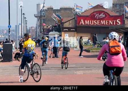 Portobello, Schottland, Großbritannien. 25. April 2020. Blick auf die Menschen im Freien am Samstagnachmittag am Strand und an der Promenade in Portobello, Edinburgh. Gutes Wetter hat mehr Menschen ins Freie gebracht, die wandern und Radfahren. Der Strand scheint voll mit möglicherweise einem Zusammenbruch der sozialen Distanz, die später am Nachmittag stattfindet. Blick auf die Promenade, die die Menschen beim Sport zeigt. Iain Masterton/Alamy Live News Stockfoto