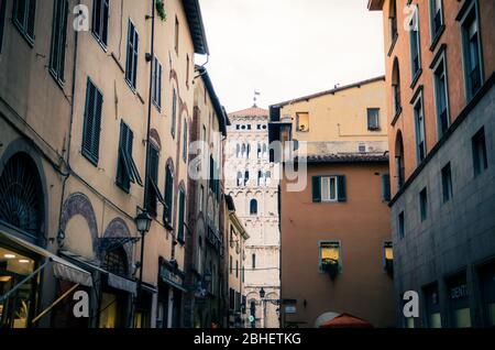 Lucca, Italien, 14. September 2018: Glockenturm der Chiesa di San Michele im Foro katholische Kirche Blick durch enge Straße in der Altstadt von alten mittelalterlichen Stadt, Abendansicht, Toskana Stockfoto