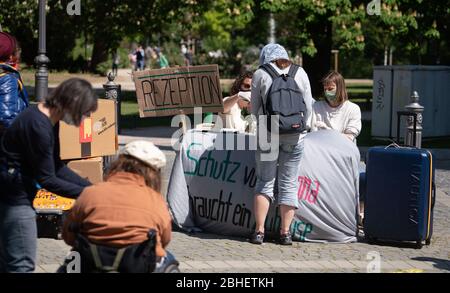 25. April 2020, Hessen, Frankfurt/Main: Vor einer provisorischen "Rezeption" "kündigen sich Demonstrationen mit Koffern und Umzugskartons am Standort eines Luxushotels im Rahmen eines Protestes an". Zum Thema "Flüchtlinge und Wohnungsmangel in der Corona-Krise" fanden vor zwei Hotels und einer Jugendherberge Aktionen statt. Foto: Frank Rumpenhorst/dpa Stockfoto