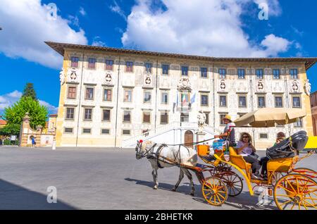 Pisa, Italien, 14. September 2018: Touristen in Kutschenwagen auf der Piazza dei Cavalieri Ritter Platz, Palazzo della Carovana Palast in der historischen Mitte der Stadt mit blauen Himmel weißen Wolken, Toskana Stockfoto