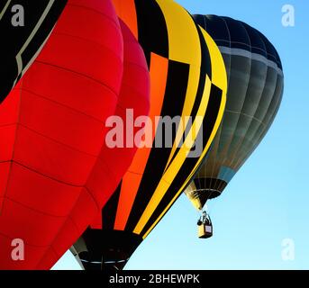 Heißluftballons fliegen im blauen klaren Himmel kurz nach dem Start Stockfoto