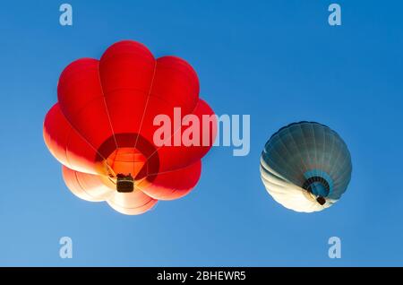 Heißluftballons fliegen im blauen klaren Himmel kurz nach dem Start Stockfoto