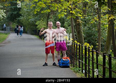 Glasgow, Großbritannien. April 2020. Im Bild: (Links-rechts) Keiran Macginley & Keir Fox, die Sonne im Park genießen. Wie das Sprichwort in Glasgow sagt, wenn die Sonne draußen ist, ist es „Taps aff“ Wetter. Szenen vom ersten Wochenende der erweiterten Sperrung des Kelvingrove Park im West End von Glasgow an einem sehr heißen und sonnigen Samstag. Quelle: Colin Fisher/Alamy Live News Stockfoto