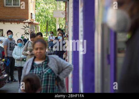 Madrid, Spanien. 25. Apr 2020. Mehrere Leute warten auf ihre Zuzug, um Nahrung zu erhalten. (Foto von Fer Capdepon Arroyo/Pacific Press) Quelle: Pacific Press Agency/Alamy Live News Stockfoto