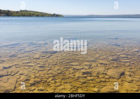 Blick auf und unter das kristallklare Wasser des Ammersees. Mit Kugeln und Steinen. Die Wasserqualität der meisten bayerischen Seen ist ausgezeichnet. Stockfoto