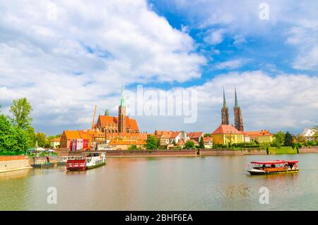 Breslau, Polen, 7. Mai 2019: Panoramablick auf Ostrow Tumski: Stiftskirche Heilig Kreuz und St. Bartholomäus, Kathedrale St. Johannes der Täufer und Boote in der oder Fluss in der historischen Innenstadt Stockfoto