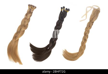 Set von mehreren gefälschten Frauen Haarverlängerungen in Schwänzen, isoliert auf weißem Hintergrund. Dunkelblond und braun. Und verschiedene Ansatztypen. Stockfoto