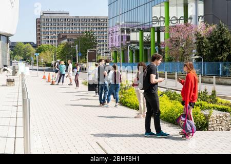 Einkäufer Schlange stehen und eine sichere 2 m soziale Distanz außerhalb Waitrose in Basingstoke während der Coronavirus Covid-19 Pandemie, 27. April 2020 Stockfoto