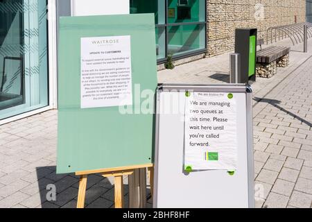 Beratung zu Tafeln außerhalb des Waitrose Supermarktes, die Kunden auf der Grundlage von staatlichen Leitlinien zur sozialen Distanzierung aufgrund von Covid 19, Großbritannien, zur Warteschlange anraten Stockfoto