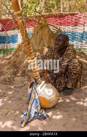 Mann, der ein Kora-Saiteninstrument im Makasutu Cutlure Forest in Gambia spielt. Stockfoto