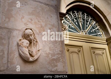 Religiöse Mutter mit Kind an der Wand außerhalb Haus, Mellieha, Malta Stockfoto