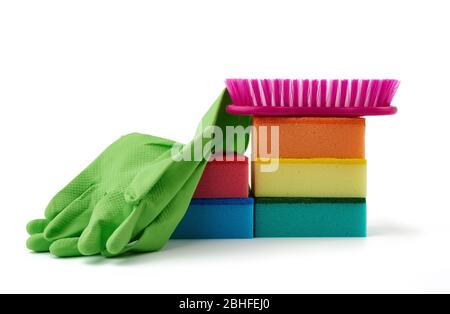 Gegenstände für die Reinigung zu Hause: Grüne Gummihandschuhe, Pinsel, mehrfarbige Schwämme zum Abstauben auf weißem Hintergrund Stockfoto