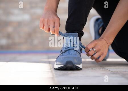 Frau, die ihre Schuhe vor dem tun Gym.determinated Mädchen in der Turnhalle bereit, Fitness lektioning.Strength und Motivation zu starten Stockfoto