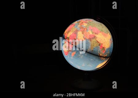 Drehbarer Globus Erdlampe Licht beleuchtet Schreibtisch Karte Geographie in der dunklen Nacht Stockfoto