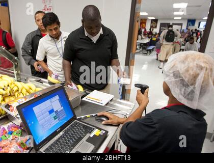 Houston, Texas 2012. Juni: Cafeteria-Mitarbeiter verwenden einen Handscanner, um Barcodeinformationen auf den Essenskarten von Schülern in einer öffentlichen Charterhochschule zu lesen. ©Marjorie Kamys Cotera/Daemmrich Photography Stockfoto