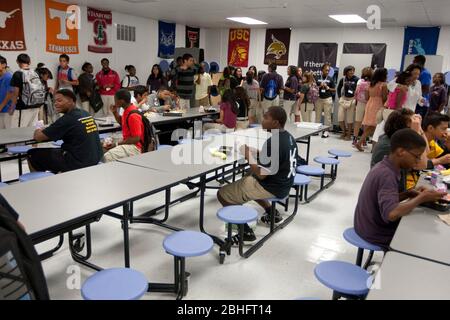 Houston, Texas Juni 2012: Afroamerikanischer Student sitzt während des Mittagessens allein am Tisch in der Cafeteria der öffentlichen Charterhochschule ©Marjorie Kamys Cotera/Daemmrich Photography Stockfoto