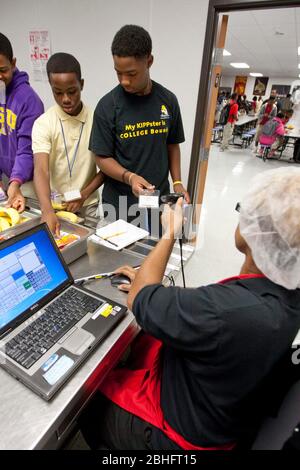 Houston, Texas 2012. Juni: Cafeteria-Mitarbeiter verwenden einen Handscanner, um Barcodeinformationen auf den Essenskarten von Schülern in einer öffentlichen Charterhochschule zu lesen. ©Marjorie Kamys Cotera/Daemmrich Photography Stockfoto