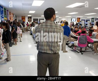 Houston, Texas 2012. Juni: Schwarzer männlicher Lehrer dient während der Mittagspause als Beobachter an einer öffentlichen Charterhochschule. ©Marjorie Kamys Cotera/Daemmrich Photography Stockfoto