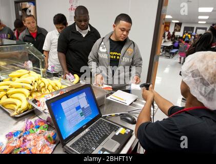 Houston, Texas 2012. Juni: Cafeteria-Mitarbeiter verwenden einen Handscanner, um Barcodeinformationen auf den Essenskarten von Schülern in einer öffentlichen Charterhochschule zu lesen. ©Marjorie Kamys Cotera/Daemmrich Photography Stockfoto