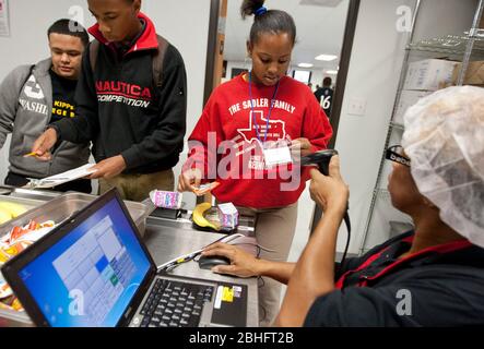 Houston, Texas 2012. Juni: Cafeteria-Mitarbeiter verwenden einen Handscanner, um Barcodeinformationen auf den Essenskarten von Schülern in einer öffentlichen Charterhochschule zu lesen. ©Marjorie Kamys Cotera/Daemmrich Photography Stockfoto