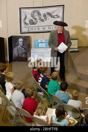 Georgetown Texas, USA, August 17 2012: Weißer Freiwilliger eines männlichen Erwachsenen, der Benjamin Franklin porträtiert, spricht an der „Vacation Liberty School“, die Kindern im Alter von 7-12 Jahren „die Vorteile der Freiheit aus der Perspektive des Glaubens, Hoffnung und Nächstenliebe“, so die Organisatoren, wurden von den amerikanischen Gründervätern bei der Schaffung der Unabhängigkeitserklärung, der Bill of Rights und der Verfassung für eine jüdisch-christliche Gesellschaft unterstützt. Obwohl es als unpolitisches Programm gegründet wurde, setzt es sich für parteileische ideale der fiskalischen Verantwortung, der freien Märkte und der begrenzten Regierung ein. ©Bob Daemmrich Stockfoto