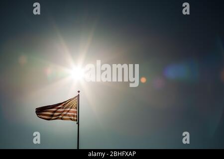 Eine einfache Zusammensetzung einer amerikanischen Flagge Hintergrundbeleuchtung mit einem sonnenschliff. Stockfoto