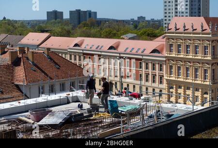 23. April 2020, Brandenburg, Potsdam: Auf dem Dach des Stützpunktes der Garnisonskirche bereiten Arbeiter der Dresdner Steinmetze und Steinbildhauerei Schubert eine Kalkmischung für die Fugen der Zementdecke vor. Im Hintergrund sind die Häuser der Dortustraße zu sehen. Im Inneren des rund 17 Meter hohen Sockelgebäudes soll auf zwei Etagen eine Kapelle, ein Café, ein großer Ausstellungsraum und Seminarräume errichtet werden. Der Umbau des Turms der ehemaligen Militärkirche soll bis Sommer 2022 abgeschlossen sein. Die Kirche wurde zwischen 1730 und 173 erbaut Stockfoto