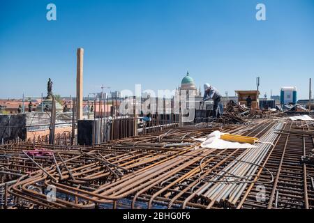 23. April 2020, Brandenburg, Potsdam: Auf dem Dach des Grundbaues der Garnisonskirche arbeitet ein Stahl- und Betonbauer an der Bewehrung für den Betonguss. Im Hintergrund sieht man die Kuppel der Kirche St. Nikolai, links eine der Figuren auf der Portalfassade des langen Stalls. Im Inneren des rund 17 Meter hohen Sockelgebäudes soll auf zwei Etagen eine Kapelle errichtet werden, neben einem Café, einem großen Ausstellungsraum und Seminarräumen. Der Umbau des Turms der ehemaligen Militärkirche soll bis Sommer 2022 abgeschlossen sein. Die Kirche Stockfoto