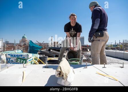 23. April 2020, Brandenburg, Potsdam: Auf dem Dach des Stützpunktes der Garnisonskirche bereiten Arbeiter der Dresdner Steinmetze und Steinbildhauerei Schubert eine Kalkmischung für die Fugen der Zementdecke vor. Im rund 17 Meter hohen Sockelgebäude soll auf zwei Etagen eine Kapelle, ein Café, ein großer Ausstellungsraum und Seminarräume errichtet werden. Der Umbau des Turms der ehemaligen Militärkirche soll bis Sommer 2022 abgeschlossen sein. Die Kirche wurde zwischen 1730 und 1735 nach den Plänen des Architekten Philipp Gerlach erbaut und war Stockfoto