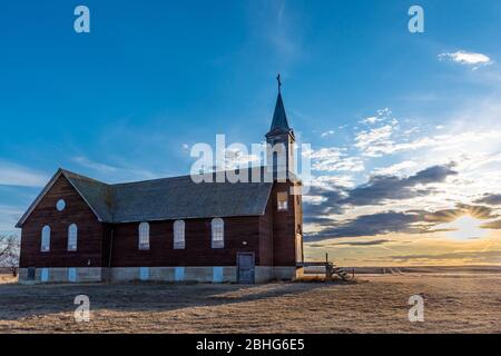 Sonnenuntergang über der verlassenen St. Joseph Parish Catholic Church in Frenchville, Saskatchewan Stockfoto