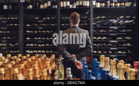 Der Barkeeper Sommelier holt eine Flasche Wein aus dem Regal im Restaurant und serviert exquisite Getränke Stockfoto