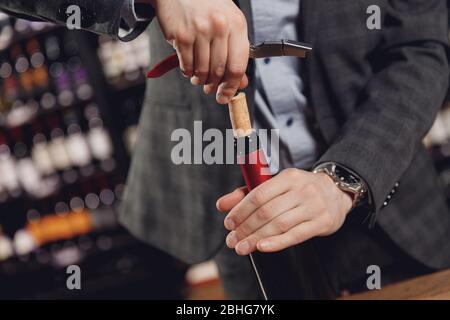 Eröffnung Weinflasche mit Korken Crew auf dunklen Hintergrund Restaurant Stockfoto