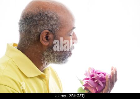 Afroamerikanischer Mann mit einer lila Rose auf weißem Hintergrund. Romantisches Konzept der Liebe, valentinstag oder Muttertag Stockfoto