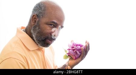 Afroamerikanischer Mann mit einer lila Rose auf weißem Hintergrund. Romantisches Konzept der Liebe, valentinstag oder Muttertag. Weißer Hintergrund mit Kopie Stockfoto