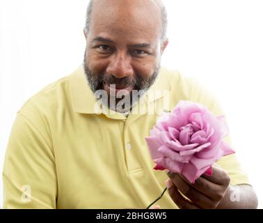 Afroamerikanischer Mann mit einer lila Rose auf weißem Hintergrund. Romantisches Konzept der Liebe, valentinstag oder Muttertag Stockfoto