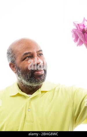 Afroamerikanischer Mann mit einer lila Rose auf weißem Hintergrund. Romantisches Konzept der Liebe, valentinstag oder Muttertag Stockfoto