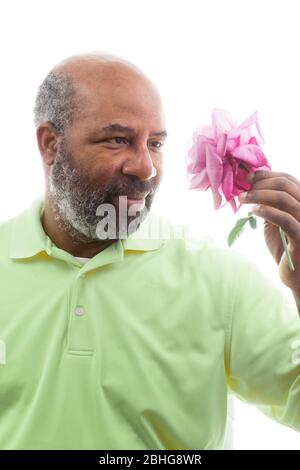 Afroamerikanischer Mann mit einer lila Rose auf weißem Hintergrund. Romantisches Konzept der Liebe, valentinstag oder Muttertag Stockfoto