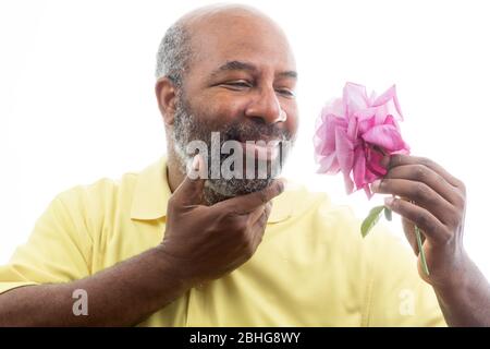 Afroamerikanischer Mann mit einer lila Rose auf weißem Hintergrund. Romantisches Konzept der Liebe, valentinstag oder Muttertag Stockfoto