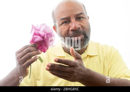 Afroamerikanischer Mann mit einer lila Rose auf weißem Hintergrund. Romantisches Konzept der Liebe, valentinstag oder Muttertag Stockfoto