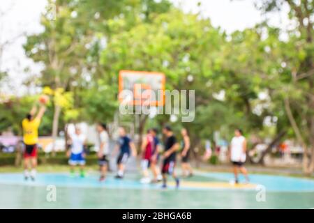Unscharfes Bild der älteren Männer und Jugendliche Basketball spielen in den Morgen im Park, BangYai Nonthaburi in Thailand. Stockfoto